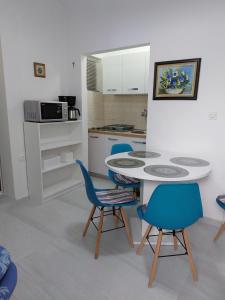 cocina con mesa y sillas azules en Apartments with a parking space Pisak, Omis - 1009, en Pisak