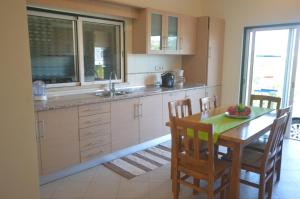 a kitchen with a wooden table with chairs and a sink at Villa Luna in Almancil