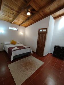 um quarto com uma cama e um tecto de madeira em Twin Casita #1 & #2 em San Pedro La Laguna