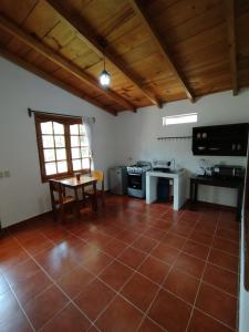 uma cozinha com piso em azulejo, uma mesa e uma janela em Twin Casita #1 & #2 em San Pedro La Laguna