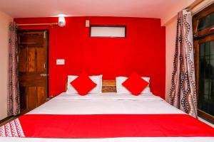 a red bedroom with a bed with red walls at OYO Flagship View Point Resort in Nainital