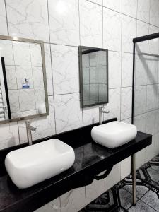 a bathroom with two sinks and mirrors on a counter at AEROHOSTEL Brasil in Guarulhos