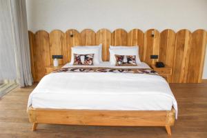 1 dormitorio con 1 cama grande y cabecero de madera en Loku, en Matara