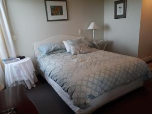 um quarto com uma cama e uma mesa com um candeeiro em The Rise em Napier