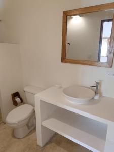 a bathroom with a toilet and a sink and a mirror at Sierra Sagrada Tayrona in Guachaca