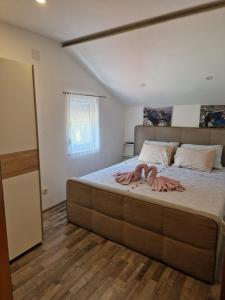 a bedroom with a large bed with two dolls on it at Family friendly house with a swimming pool Imotski, Zagora - 22880 in Imotski