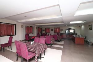 a dining room with pink chairs and a table at SPOT ON Hotel Center Point in Rāmpura