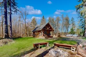 a cabin in the woods with two benches in front at Schillinger Fields in Toledo