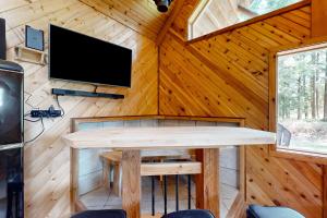 a room with a table and a tv on a wooden wall at Schillinger Fields in Toledo