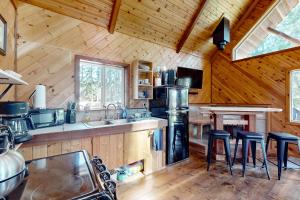a kitchen with a stove and stools in a cabin at Schillinger Fields in Toledo