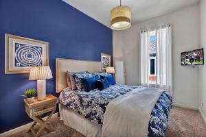 Schlafzimmer mit blauen Wänden und einem Bett mit blauen Kissen in der Unterkunft Nashville - 931 Russell St Apt D in Nashville