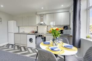 a kitchen and dining room with a table and chairs at Coventry 2 Bedroom Apartment, Sleeps 4, Parking in Wyken
