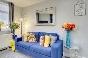 a blue couch in a living room with a mirror at Coventry 2 Bedroom Apartment, Sleeps 4, Parking in Wyken