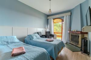 1 dormitorio con 2 camas y chimenea en Mineir.INN - Piscina Aquecida e Hidro na Montanha, en Campos do Jordão