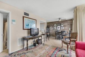 a living room with a couch and a television and a table at Sandpiper Cove 2017 in Destin