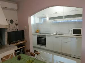 una cucina bianca con lavello e microonde di Seaside house with a swimming pool Prigradica, Korcula - 22904 a Blato