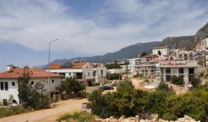 eine Stadt mit Häusern und Bergen im Hintergrund in der Unterkunft Kaş Güzey apart 3+1 Doğa ve deniz manzaralı in Kaş