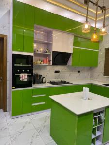 Two bedroom duplex in Chevron Lekki phase 2 في Iranla: مطبخ اخضر وبيض مع دواليب خضراء