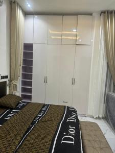 Two bedroom duplex in Chevron Lekki phase 2 في Iranla: غرفة نوم بسرير ودواليب بيضاء