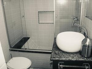 y baño con aseo, lavabo y ducha. en Excelente apto -smart tv- melhor localização no Leblon, en Río de Janeiro