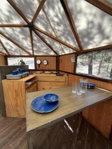 Los Lirios的住宿－Glamping en la Sierra de Arteaga，厨房里设有一张桌子,上面有蓝色的盘子