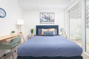 a bedroom with a large blue bed and a desk at 1BD Perfect location Walk to CN Tower! in Toronto