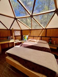 Glamping en la Sierra de Arteaga في Los Lirios: غرفة نوم مع سرير كبير في يورت