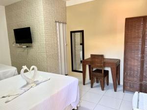 1 dormitorio con escritorio, 1 cama y 1 mesa en Mar de Guarajuba en Guarajuba