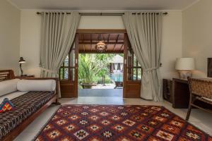 a bedroom with a bed and a door to a patio at Villa Balidamai by Nagisa Bali in Kerobokan