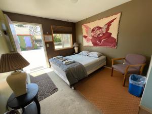 1 dormitorio con 1 cama y una pintura en la pared en Seaside International Hostel, en Seaside