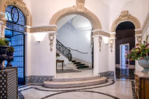 un pasillo ornamentado con escaleras y un arco en Hotel Palacio del Retiro, Autograph Collection en Madrid