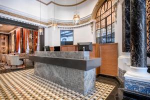 a lobby with a reception desk in a building at Hotel Palacio del Retiro, Autograph Collection in Madrid