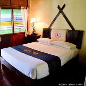 Llit o llits en una habitació de Golden Triangle Palace Hotel