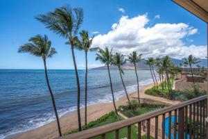 a view of a beach with palm trees and the ocean at KIHEI BEACH #504 condo in Kihei