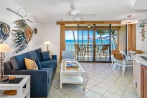 a living room with a blue couch and a table at KIHEI BEACH #504 condo in Kihei