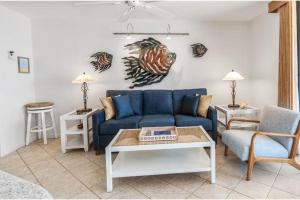 a living room with a blue couch and a table at KIHEI BEACH #504 condo in Kihei