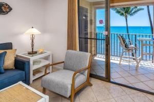 a living room with a couch and a balcony with the ocean at KIHEI BEACH #504 condo in Kihei +29 photos