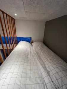 um pequeno quarto com uma cama no canto em Rosie’s Neyst em Vestnanhavn