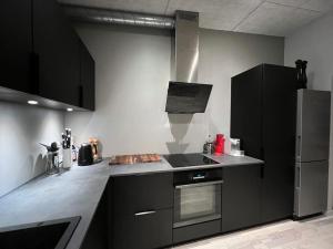 una cucina con mobili neri e un forno a piano cottura di Rosie’s Neyst a Vestnanhavn Altre 54 foto