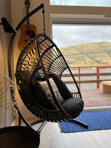 un'altalena nera appesa a un muro con una chitarra di Rosie’s Neyst a Vestnanhavn