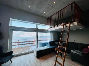 un soggiorno con letto a soppalco e scala a pioli. di Rosie’s Neyst a Vestnanhavn