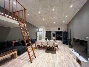 a living room with a dining room table and a staircase at Rosie’s Neyst in Vestmanna