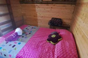 een slaapkamer met een bed met een roze deken bij Eco Aldea Cabaña entre helechos in Medellín