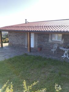 a house with a patio and a table and a chair at O Recanto do Sobreiro in Vale de Porco