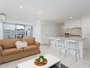 a living room with a couch and a kitchen at Three Bedroom, Two Bathroom Family Home in Coogee