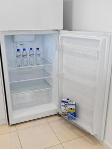 an open refrigerator with bottles of water in it at Three Bedroom, Two Bathroom Family Home in Coogee
