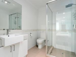 a bathroom with a toilet and a glass shower at Three Bedroom, Two Bathroom Family Home in Coogee