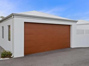 a garage door on a white house at Three Bedroom, Two Bathroom Family Home in Coogee