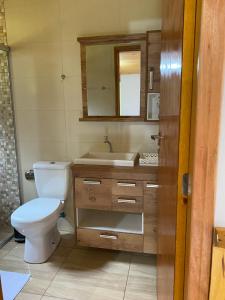 a bathroom with a toilet and a sink and a mirror at Chalé Recanto Belo. in São Mateus +28 photos