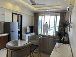 een woonkamer met een bank en een tafel met stoelen bij Elysium Luxury One Bedroom Apartment Opposite Centaurus Mall Islamabad in Islamabad